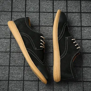 Detail of black suede Brogue dress shoes with tan rubber soles and contrast stitching.
