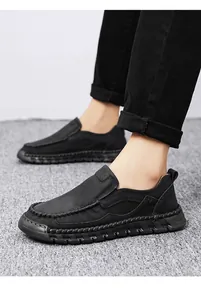 Macro detail view of black hand-stitched men's leather slip-on casual loafers