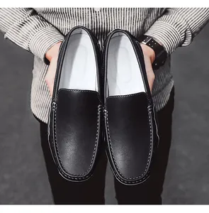 Vista detallada de mocasines de cuero negro para hombre con costuras blancas y suelas blandas