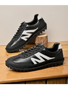 Detailansicht der retro Herren-Sneaker in Schwarz-Weiß mit weicher Sohle auf Holz.