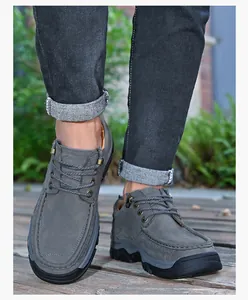 Vue de face de mocassins d'extérieur en cuir gris pour hommes sur un pont en bois rustique