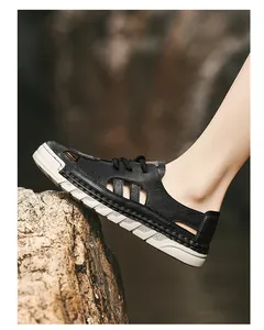 Side view of breathable black cut-out leather sandals for men stepping on a rock