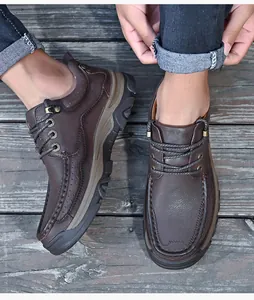 Vue détaillée de dessus de mocassins en cuir véritable marron foncé sur une terrasse en bois