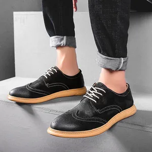 Detail of men's black brogue shoes with decorative perforation on concrete steps