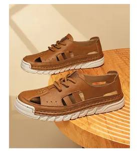 Detailed view of brown hollowed-out men's leather sandals placed on a wooden table
