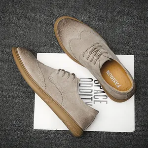 Close-up detail of men's taupe brogue leather shoes displayed on a magazine backdrop