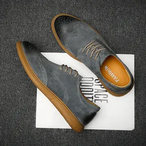 Close-up of grey leather Brogue shoes with tan soles on a minimalist background