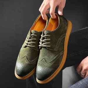 Macro detail of olive green suede brogue shoes featuring elegant wingtip carving