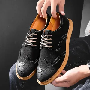Close-up of mens black suede brogue shoes with classic wingtip punching detail