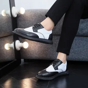 Close-up view of black and white men's brogue shoes paired with stylish black trousers