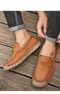 Detail view of retro handmade soft leather loafers with stitching details on wood