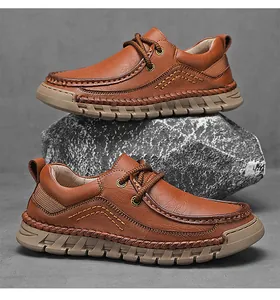 Zwei braune handgenähte Herren-Lederschuhe, gestapelt auf einem grauen Naturfelsen.