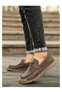 Close-up of men's retro brown leather loafers with handmade stitching and soft rubber sole