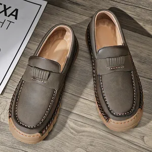 Classic retro men's handmade leather slip-on loafers shown on a wooden textured background