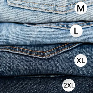 Macro view of M, L, XL, and 2XL round size stickers applied to a stack of denim jeans