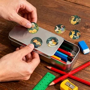 Close-up view of cute cartoon children and animal stickers applied to a metal tin box.