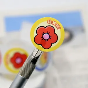Gros plan d'un autocollant de récompense rond avec fleur rouge