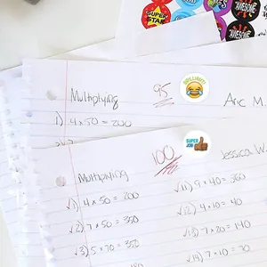 Gros plan sur des autocollants d'encouragement emoji sur des devoirs scolaires notés