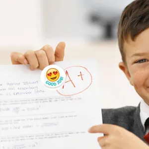 Vue détaillée d'un autocollant de récompense emoji 'Good Job' sur une copie d'examen