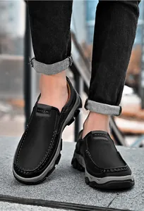 Nahaufnahme von schwarzen Herren-Slippern aus Leder, getragen zu lässigen Jeans.