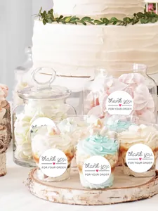 Detailed view of round white 'Thank you for your order' sealing stickers on dessert cups.