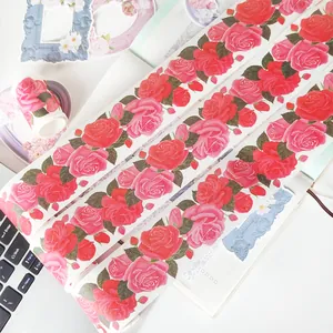 Dettaglio ravvicinato di nastro washi floreale con rose rosse vintage da 5 cm su un taccuino.