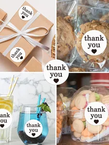 Lifestyle view of 1-inch round white 'thank you' sealing stickers on gift packaging