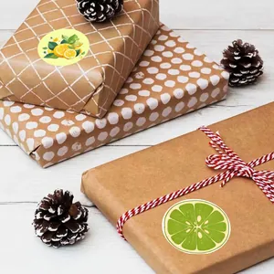 Lemon pattern round sealing stickers on wrapped brown gift boxes with pine cones