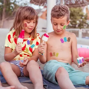 Bunte Laser-Glitzer-Eis-Sticker auf Kindern am sommerlichen Strand im Detail