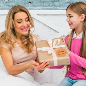 Primo piano di un'etichetta regalo rotonda beige su una scatola durante un dono speciale