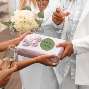 Primo piano di un'etichetta regalo circolare verde su una confezione regalo di nozze