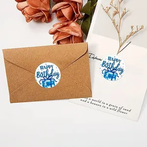 Detailed view of circular Happy Birthday stickers sealing brown kraft envelopes
