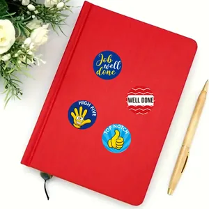Lot d'autocollants de récompense colorés sur un cahier rouge pour motiver les élèves