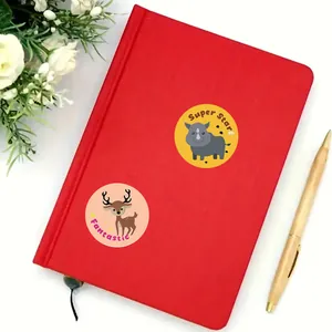 Close-up of colorful cartoon animal reward stickers applied on a red notebook cover.