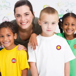 Enfants portant des autocollants de récompense comme Well Done et Excellence