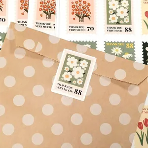 Detail van een bloemensticker die een bruine envelop met witte stippen verzegelt