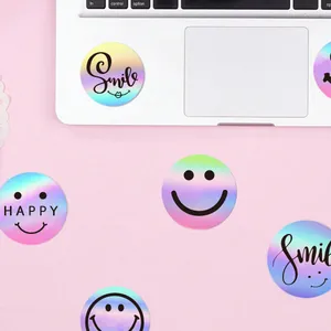 Close-up of holographic round smile stickers with HAPPY and Smile text on a laptop