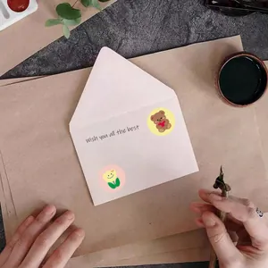 Autocollants mignons d'ours et de tulipes décorant une enveloppe dans une scène DIY