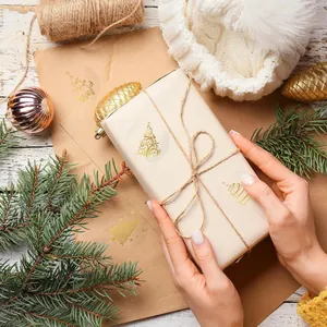 Close-up of golden Christmas tree stickers used for elegant holiday gift wrapping decoration