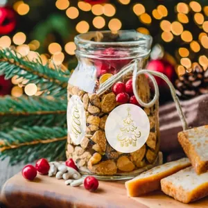 Detail view of gold-stamped transparent Christmas tree stickers on a glass gift jar