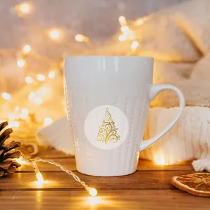Close-up of gold foil Christmas tree sticker applied on a textured white ceramic mug