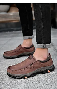 Detailliertes Seitenprofil von braunen Herren-Outdoor-Loafers aus Leder auf Steinpflaster