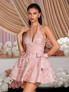 Detailed view of pink halter neck deep V jacquard dress featuring large bow accents.