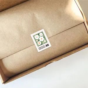 Detailweergave van een bloemige bedanksticker in de vorm van een postzegel op een doos