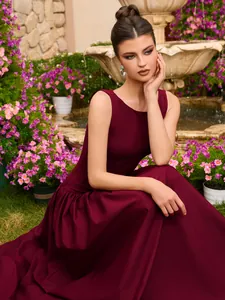 Detailaufnahme eines weinroten ärmellosen Satin-Abendkleids im Garten
