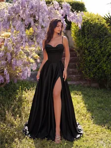Elegante abito da sera in raso nero con spacco alto e bustino in un giardino fiorito.