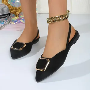 Détail de chaussures plates noires à bout pointu avec boucle dorée et noire