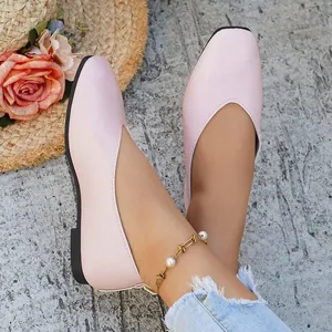 Close-up detail of elegant light pink V-cut women's flats with textured leather finish.