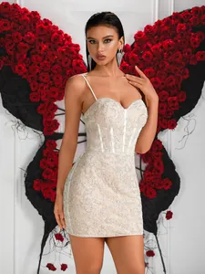 Gros plan d'une robe corset en dentelle blanche avec paillettes et fines bretelles.
