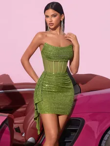Detailaufnahme des grünen Pailletten-Minikleids mit transparentem Netzkorsett-Bund.